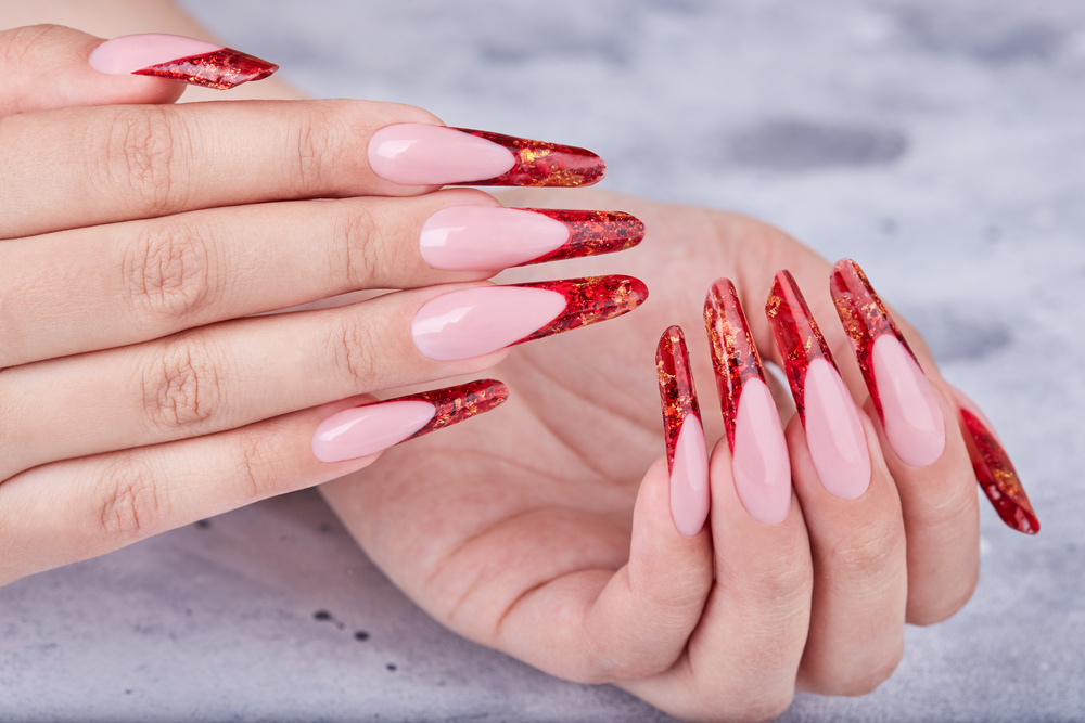 Hands with long red artificial french manicured nails