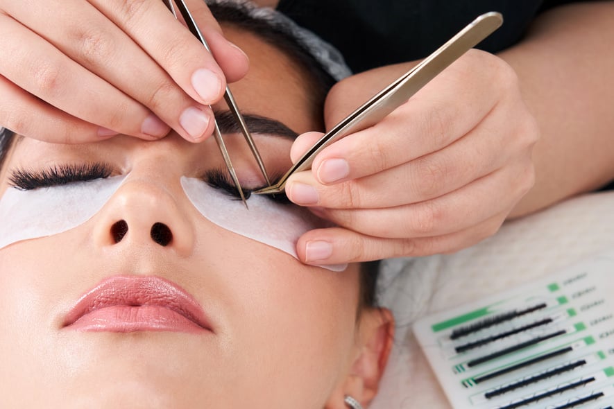 Eyelash Extension Procedure. Woman Eye with Long Eyelashes